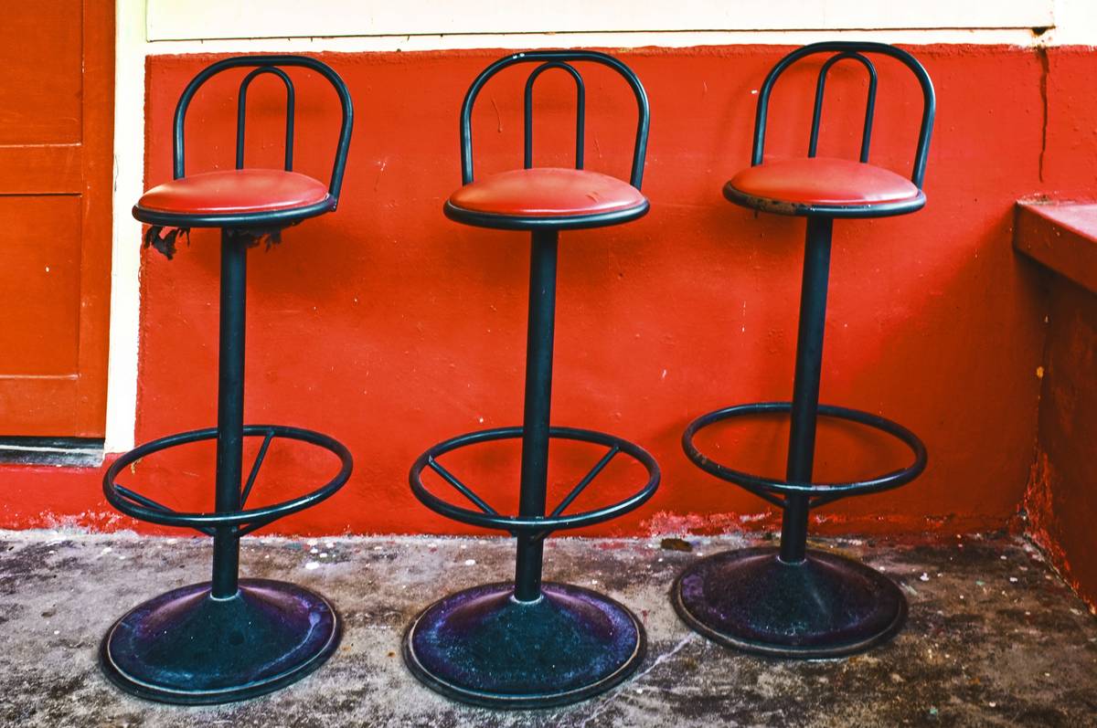 Side-by-side comparison of worn residential bar stools vs durable bar stools for restaurant durability